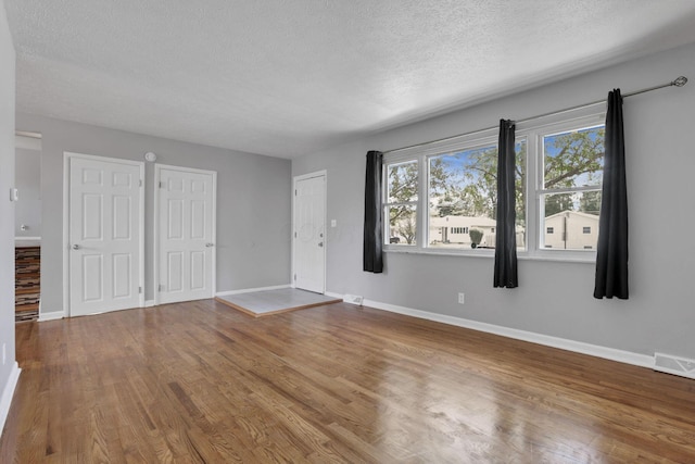 1698 Woodcrest Rd, Columbus, OH 43232 - unfurnished living room featuring a textured ceiling and wood finished floors