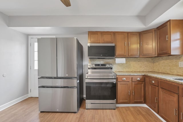 1698 Woodcrest Rd, Columbus, OH 43232 - kitchen with appliances with stainless steel finishes, light wood-type flooring, brown cabinets, and decorative backsplash