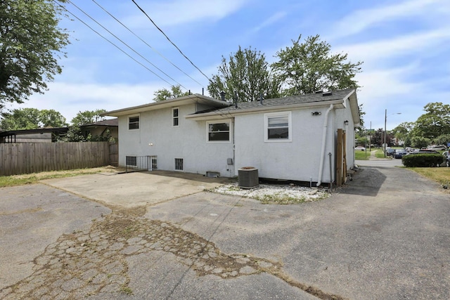 1698 Woodcrest Rd, Columbus, OH 43232 - rear view of house featuring stucco siding, driveway, and a patio