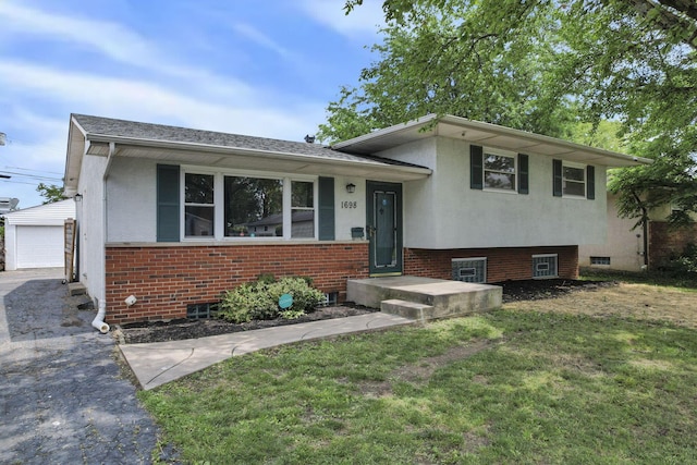 1698 Woodcrest Rd, Columbus, OH 43232 - tri-level home with a front yard, brick siding, an outbuilding, stucco siding, and a garage