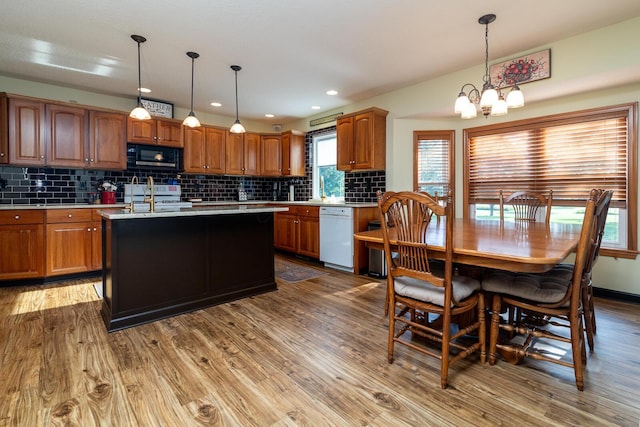 1163 Sitterley Rd NW, Canal Winchester, OH 43110 - kitchen with white appliances, a chandelier, light countertops, tasteful backsplash, and wood finished floors