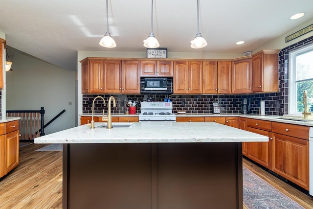 1163 Sitterley Rd NW, Canal Winchester, OH 43110 - kitchen featuring white range with gas stovetop, black microwave, light wood-type flooring, decorative backsplash, and recessed lighting
