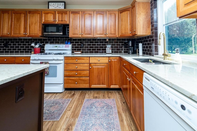 1163 Sitterley Rd NW, Canal Winchester, OH 43110 - kitchen with white appliances, brown cabinetry, light wood finished floors, and decorative backsplash