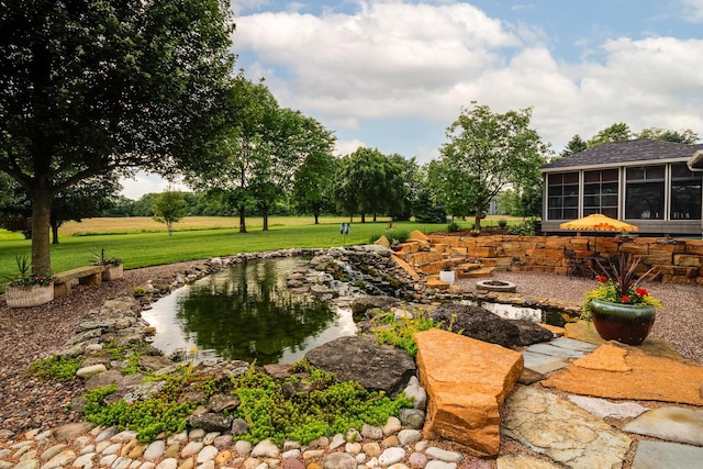1163 Sitterley Rd NW, Canal Winchester, OH 43110 - view of grassy yard featuring a fire pit, a sunroom, and a small pond