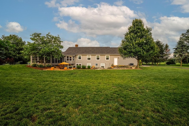 1163 Sitterley Rd NW, Canal Winchester, OH 43110 - rear view of house with a sunroom, a lawn, and a chimney