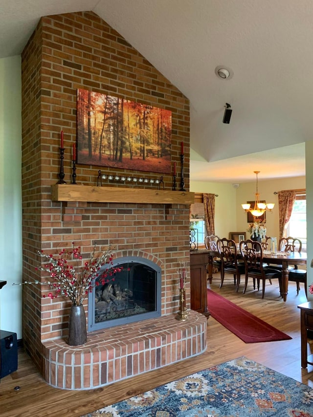 1163 Sitterley Rd NW, Canal Winchester, OH 43110 - living area featuring lofted ceiling, wood finished floors, a brick fireplace, and a chandelier