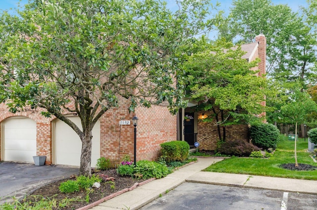 5092 Schuylkill St Unit 31-92, Columbus, OH 43220 - view of property hidden behind natural elements featuring brick siding, a front yard, and a garage
