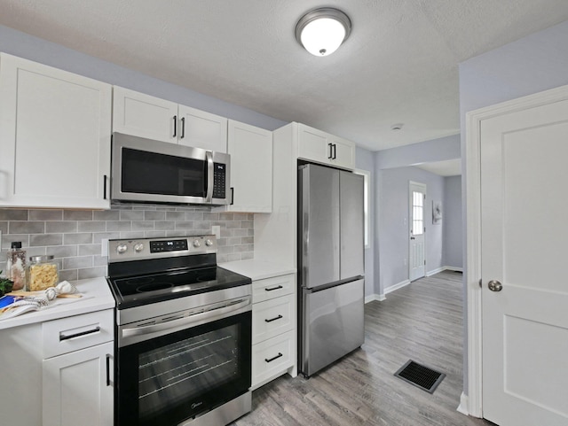 315 S Southampton Ave, Columbus, OH 43204 - kitchen featuring appliances with stainless steel finishes, light countertops, tasteful backsplash, light wood-style flooring, and a textured ceiling
