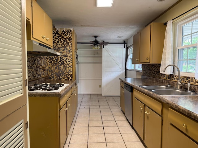 1628 Lucks Rd, Reynoldsburg, OH 43068 - kitchen with under cabinet range hood, white gas stovetop, dishwasher, backsplash, and light tile patterned floors