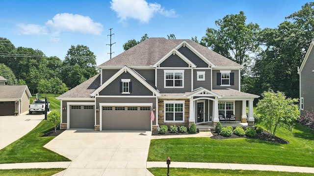 3860 Coldwater Loop, Powell, OH 43065 - craftsman inspired home featuring concrete driveway, a front yard, a porch, an attached garage, and stone siding