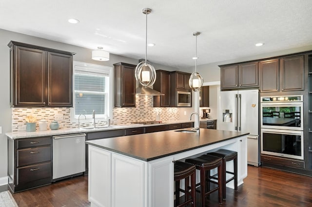 3860 Coldwater Loop, Powell, OH 43065 - kitchen with appliances with stainless steel finishes, dark brown cabinets, dark wood finished floors, decorative backsplash, and recessed lighting