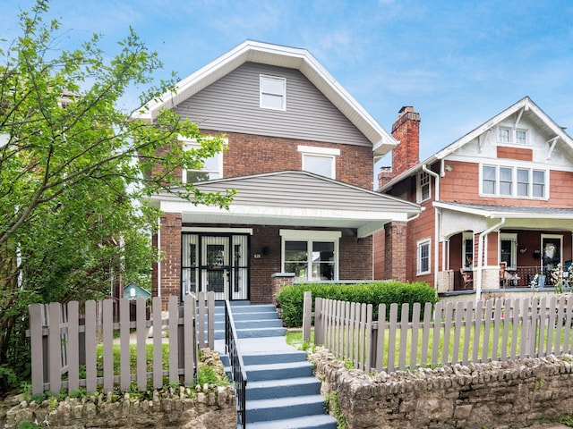 935 S Ohio Ave, Columbus, OH 43206 - american foursquare style home featuring a porch, brick siding, and a fenced front yard