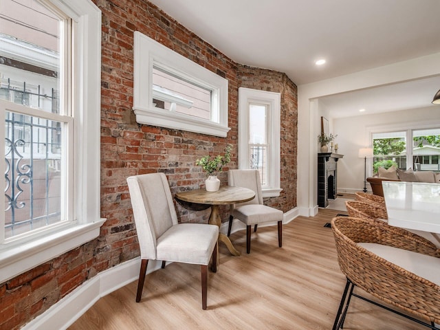 935 S Ohio Ave, Columbus, OH 43206 - dining room with brick wall, light wood-type flooring, and a fireplace