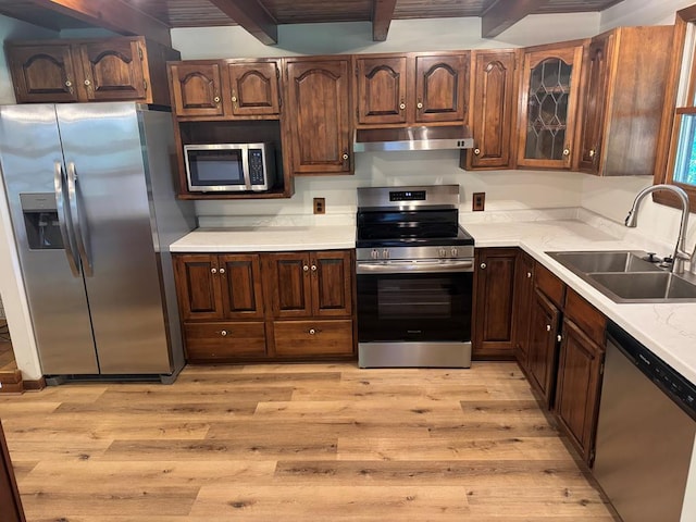 300 Core Rd, Frankfort, OH 45628 - kitchen with appliances with stainless steel finishes, under cabinet range hood, light wood-style floors, light countertops, and beam ceiling