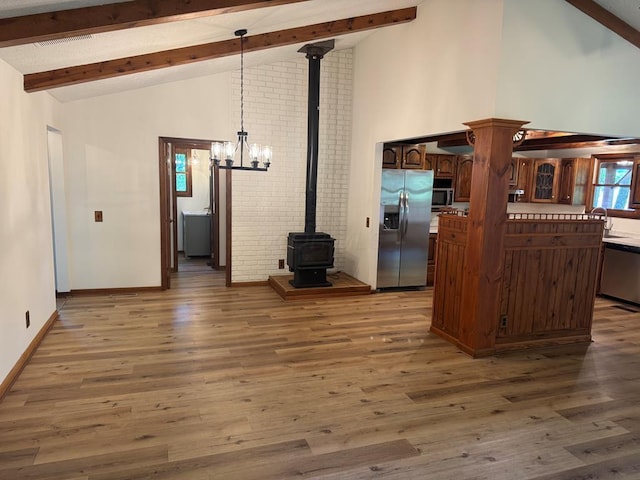 300 Core Rd, Frankfort, OH 45628 - unfurnished living room featuring a wood stove, high vaulted ceiling, beamed ceiling, wood finished floors, and a chandelier