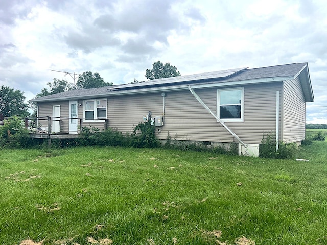 4345 Lancaster Kirkersville Rd NW, Lancaster, OH 43130 - view of side of property with roof mounted solar panels, a lawn, a deck, and a shingled roof
