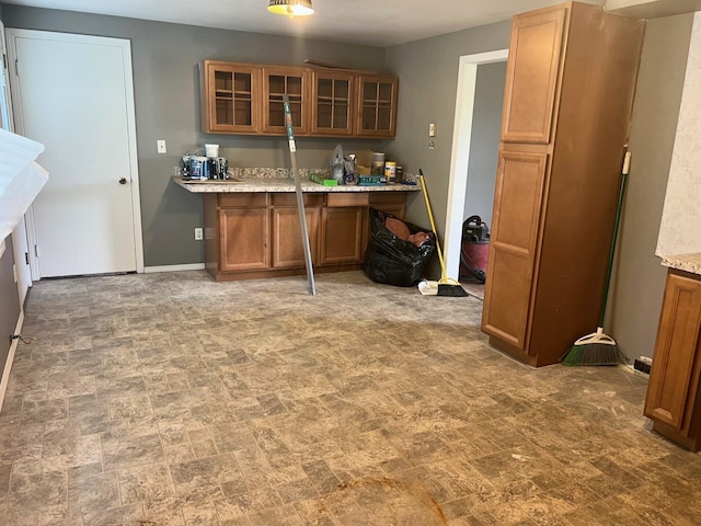 4345 Lancaster Kirkersville Rd NW, Lancaster, OH 43130 - kitchen with brown cabinets, glass insert cabinets, stone finish floors, an office area, and light stone counters