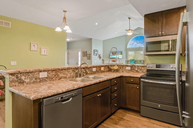 3242 Rossmore Cir, Powell, OH 43065 - kitchen with stainless steel appliances, ceiling fan, light wood-type flooring, a peninsula, and vaulted ceiling