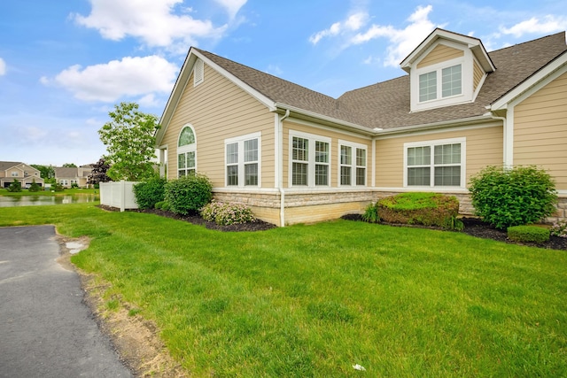 3242 Rossmore Cir, Powell, OH 43065 - view of side of property with a shingled roof, stone siding, and a yard