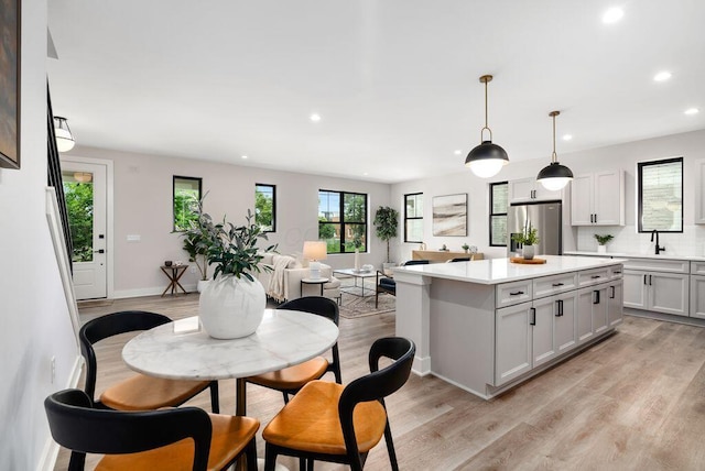 546 W Town St, Columbus, OH 43215 - kitchen with stainless steel fridge, recessed lighting, light wood-style floors, light countertops, and a center island