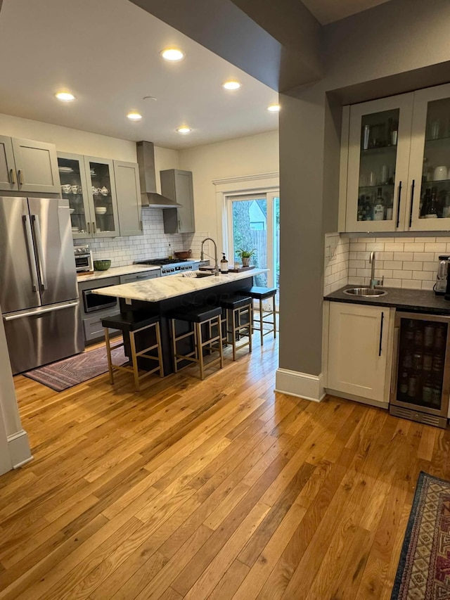 489 W 4th Ave, Columbus, OH 43201 - kitchen featuring high quality fridge, wall chimney exhaust hood, wine cooler, decorative backsplash, and gray cabinetry