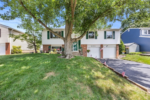 6492 Cherokee Rose Dr, Westerville, OH 43081 - view of front of house with brick siding, asphalt driveway, an attached garage, and a front lawn