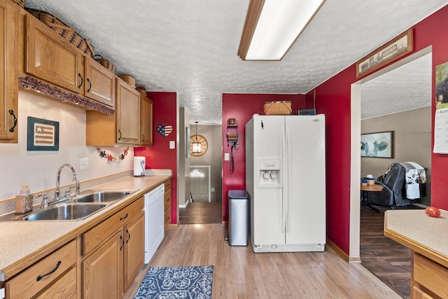 6492 Cherokee Rose Dr, Westerville, OH 43081 - kitchen with white appliances, a textured ceiling, light wood-style flooring, light countertops, and brown cabinetry