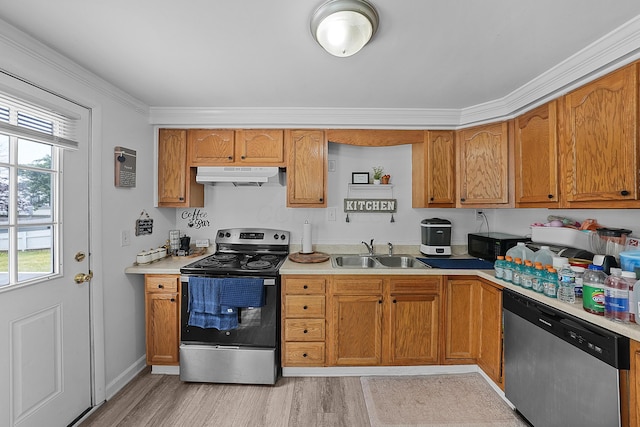 1310 Sweetbay Pl, Galloway, OH 43119 - kitchen with stainless steel appliances, under cabinet range hood, light countertops, brown cabinetry, and light wood-style flooring