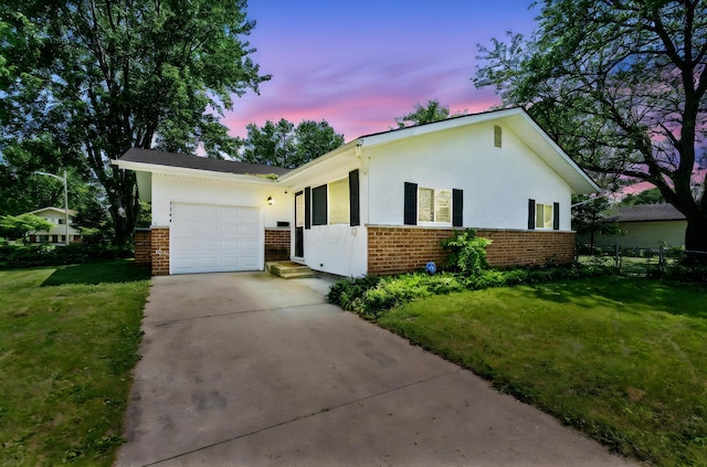 1894 Orlando Rd, Columbus, OH 43232 - view of front of home with brick siding, driveway, a garage, and stucco siding