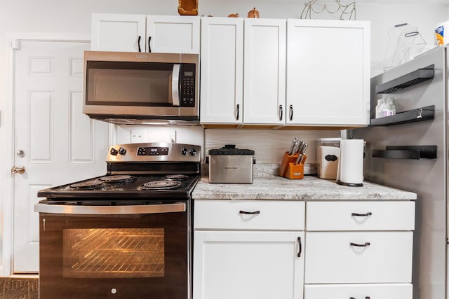 1894 Orlando Rd, Columbus, OH 43232 - kitchen with stainless steel appliances, white cabinets, and light stone counters