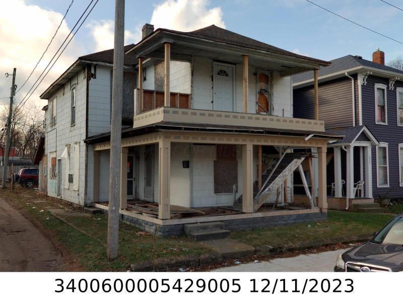 821 W Columbia St, Springfield, OH 45504 - view of front facade featuring a porch, a chimney, and stairway
