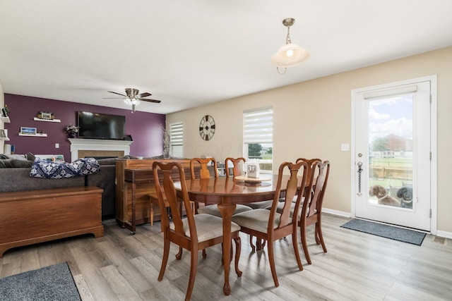 208 Dowler Dr, South Bloomfield, OH 43103 - dining area with a ceiling fan, light wood-style flooring, and a fireplace