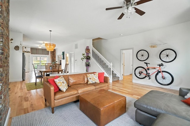 192 E Morrill Ave, Columbus, OH 43207 - living room featuring light wood-style flooring, stairway, ceiling fan, and a chandelier
