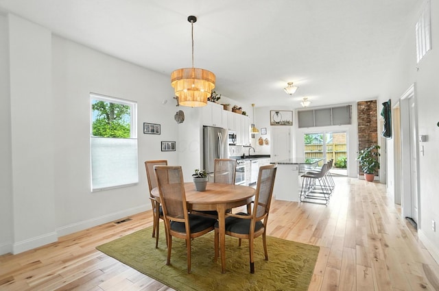 192 E Morrill Ave, Columbus, OH 43207 - dining space with light wood-style floors and a chandelier