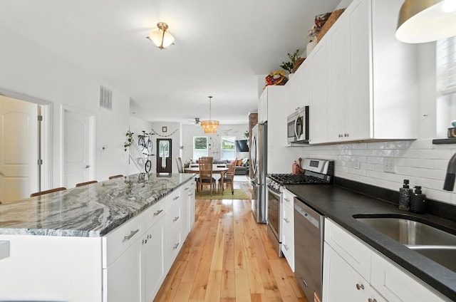 192 E Morrill Ave, Columbus, OH 43207 - kitchen with stainless steel appliances, a kitchen island, backsplash, and white cabinetry