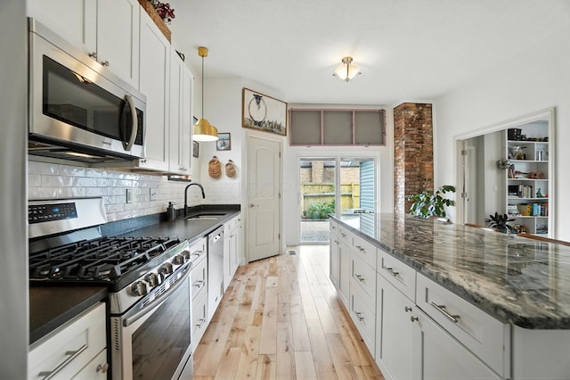 192 E Morrill Ave, Columbus, OH 43207 - kitchen featuring appliances with stainless steel finishes, backsplash, light wood-style flooring, and white cabinets