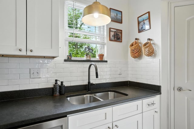 192 E Morrill Ave, Columbus, OH 43207 - kitchen with dark countertops, white cabinets, decorative backsplash, dishwasher, and decorative light fixtures