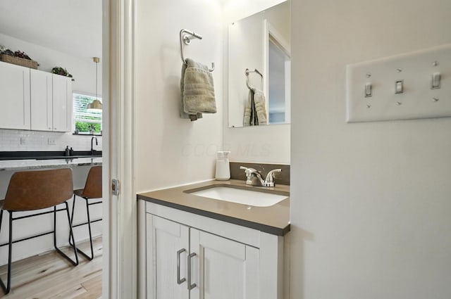 192 E Morrill Ave, Columbus, OH 43207 - bathroom featuring backsplash, vanity, and wood finished floors