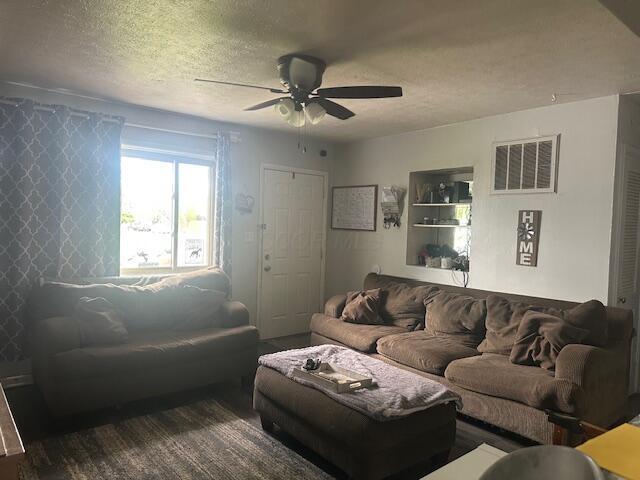 3519 Ontario St, Columbus, OH 43224 - living area featuring ceiling fan and a textured ceiling
