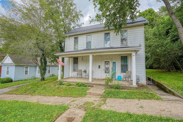 206 W Water St, New Lexington, OH 43764 - view of front of house with a porch, a front yard, and a metal roof
