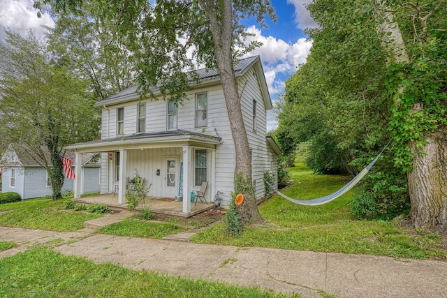 206 W Water St, New Lexington, OH 43764 - view of front of home featuring covered porch, a front lawn, and board and batten siding