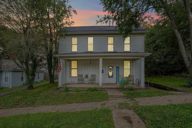 206 W Water St, New Lexington, OH 43764 - view of front facade featuring a porch, a metal roof, roof mounted solar panels, and a front lawn