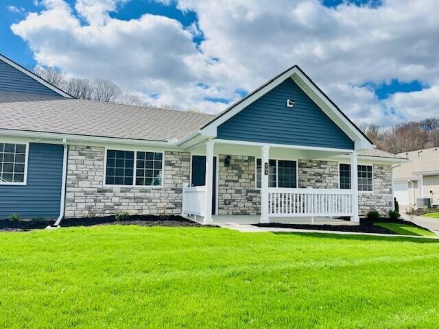 763 Whitetail Loop, Newark, OH 43055 - view of front of house featuring stone siding, covered porch, and a front yard
