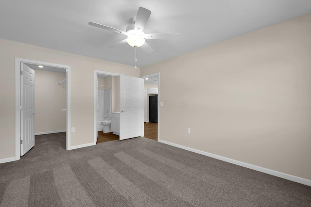 763 Whitetail Loop, Newark, OH 43055 - unfurnished bedroom with dark carpet, a walk in closet, ensuite bathroom, a closet, and a ceiling fan