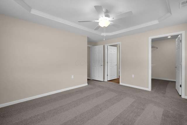 763 Whitetail Loop, Newark, OH 43055 - unfurnished bedroom featuring a raised ceiling, ornamental molding, carpet, a walk in closet, and ceiling fan