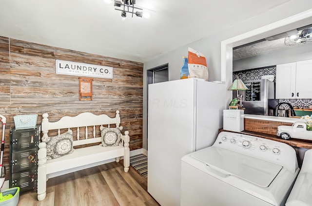 599 S Brinker Ave, Columbus, OH 43204 - washroom featuring washer / dryer, wooden walls, wood finished floors, and an accent wall