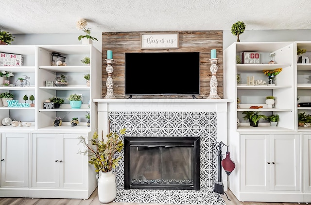599 S Brinker Ave, Columbus, OH 43204 - living area featuring a tile fireplace, a textured ceiling, and light wood-style floors