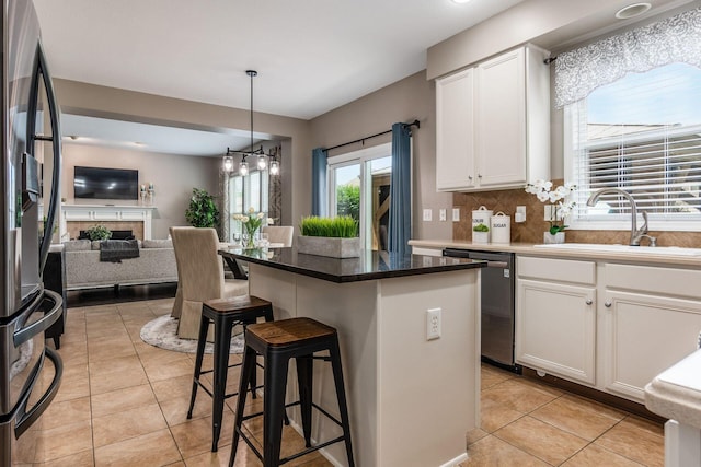 333 Quarter Way, Delaware, OH 43015 - kitchen with stainless steel dishwasher, a breakfast bar area, open floor plan, light tile patterned flooring, and white cabinets