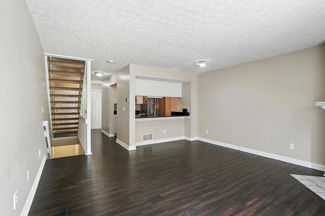 1812 Bennigan Dr Unit 88C, Hilliard, OH 43026 - unfurnished living room with dark wood finished floors, a textured ceiling, and stairs