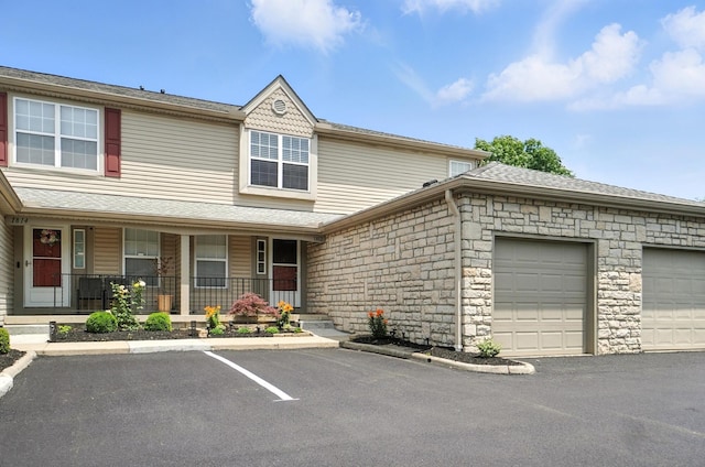 1812 Bennigan Dr Unit 88C, Hilliard, OH 43026 - view of front facade featuring a porch, stone siding, and a garage